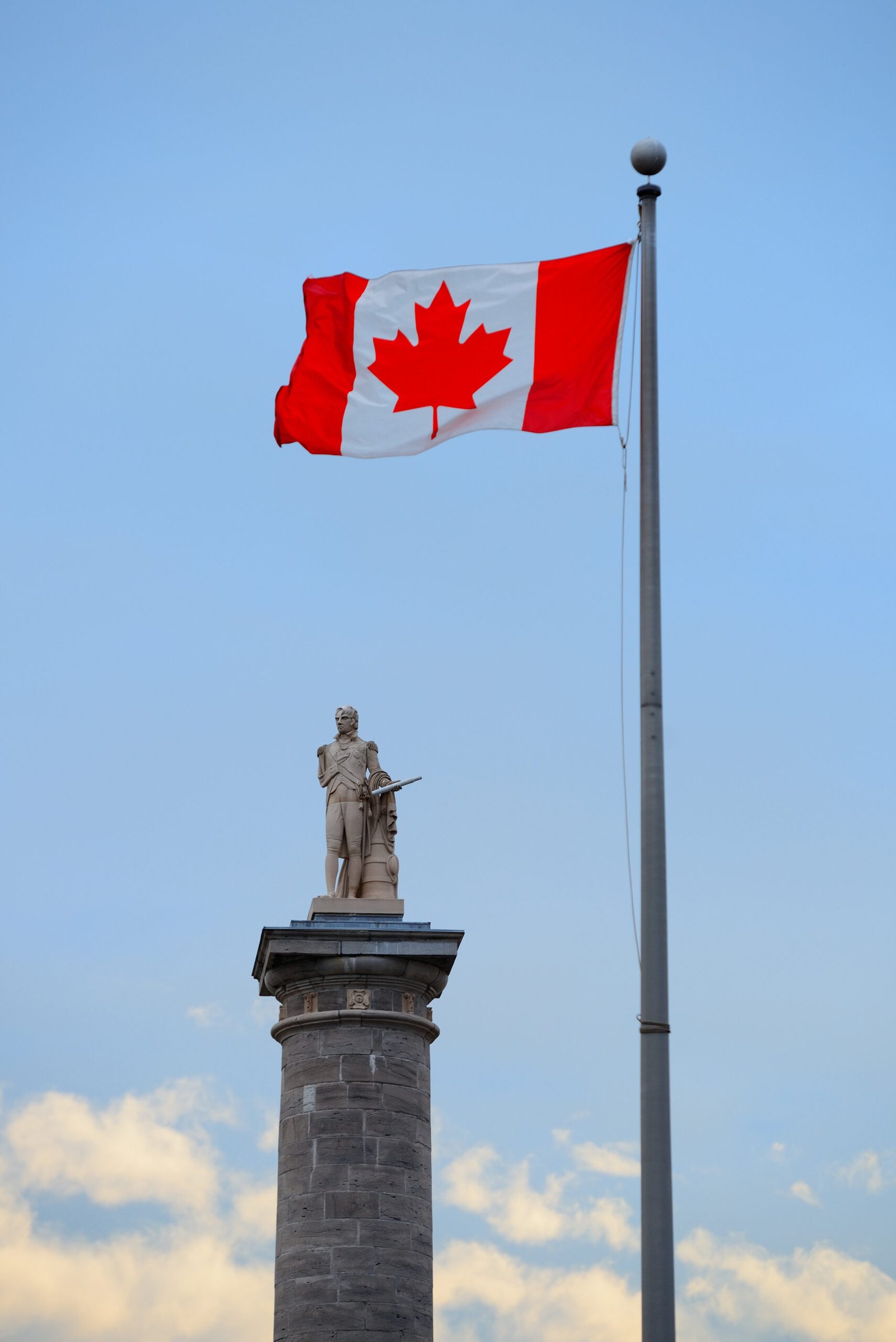 Montreal architecture with statue and Canada National Flag
